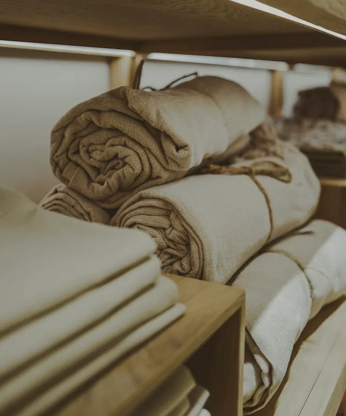 Rolled and folded towels on timber shelves