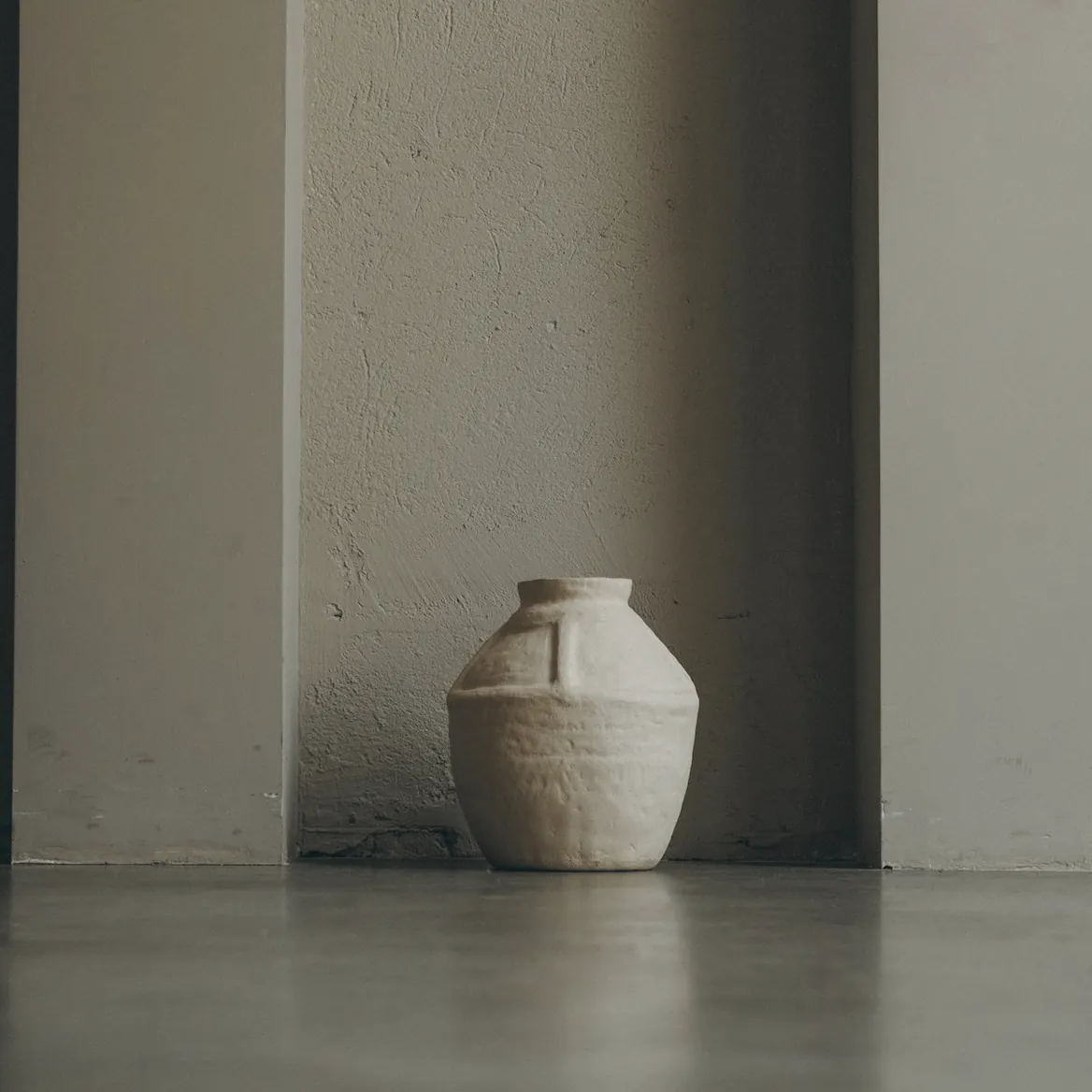 A handmade vessel at the end of a plaster corridor