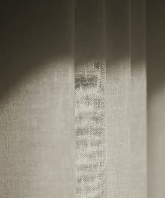 The weave of a linen curtain catching the light